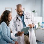 Doctor discussing test results with female patient in modern medical office.