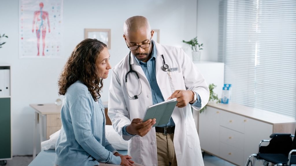 Doctor discussing test results with female patient in modern medical office.
