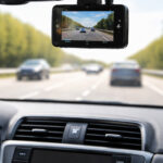Car dashboard with dashcam recording a highway view with cars driving.